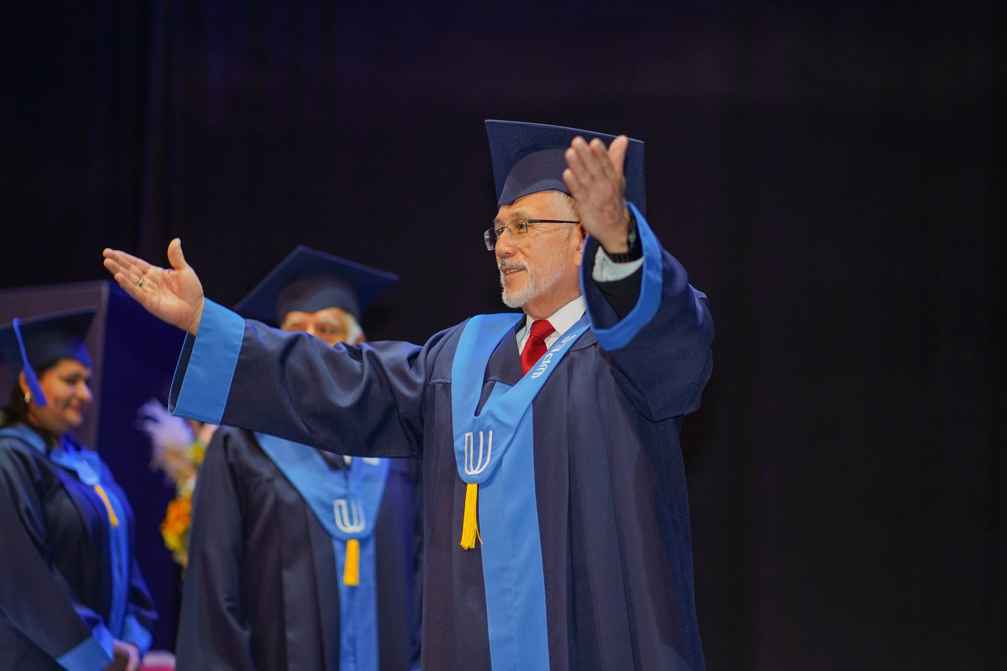 El rector saluda al público durante una ceremonia de graduación