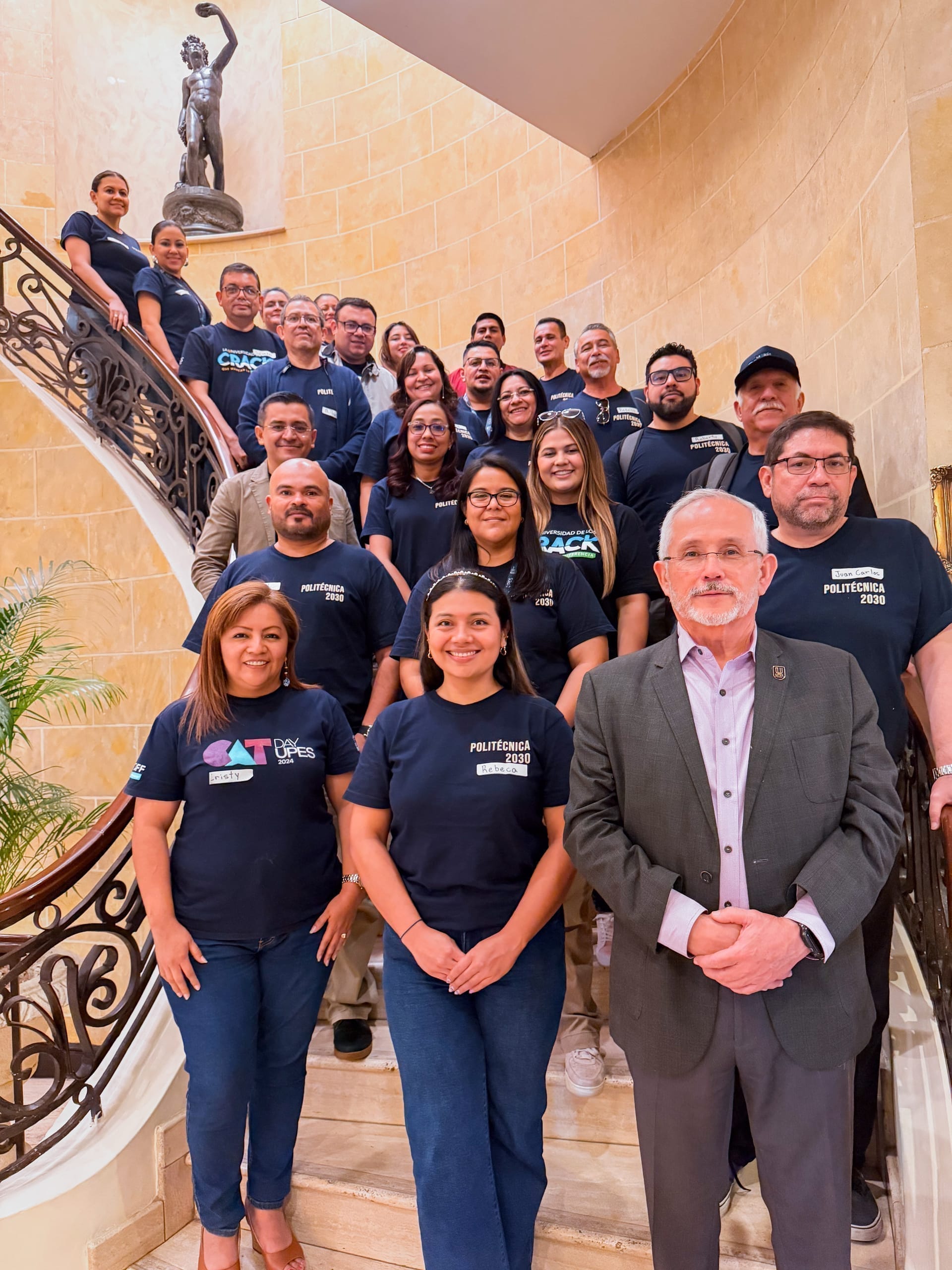 Grupo de colaboradores posando en una escalinata con playeras "Politécnica 2030"