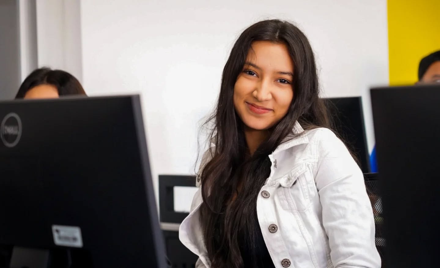 Estudiante sonriendo en el laboratorio de cómputo
